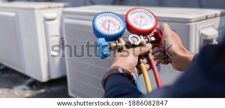 Technician is checking air conditioner ,measuring equipment for filling air conditioners. Royalty-Free Stock Photo #1886082847