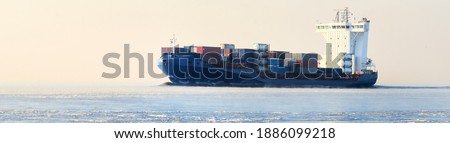 Large cargo container ship sailing in a still water. Concept winter seascape. Ecology, environment, climate change, expedition, work, research, Arctic shipping routes, logistics, global communications