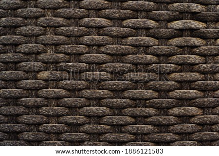 Wicker background made of brown plastic. Rough texture in dark colors. Blank for the designer. Full frame