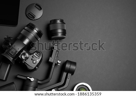 Flat lay composition with camera and video production equipment on black background. Space for text
