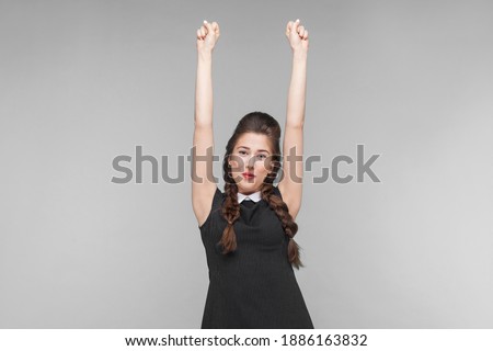 Victory! Successful young woman rejoicing her win. Indoor, studio shot isolated on gray background
