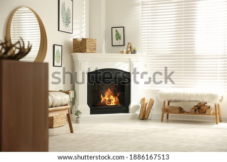 Bright living room interior with artificial fireplace and firewood
