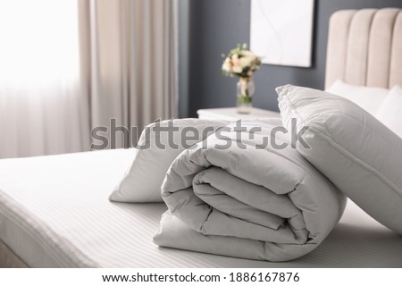 Soft folded blanket and pillows on bed indoors Royalty-Free Stock Photo #1886167876