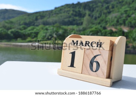 March 16, Date design with number cube on white table, cover design in natural concept.
