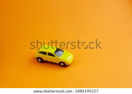 yellow toy car on yellow background, concept idea of taxi and cargo delivery during quarantine.