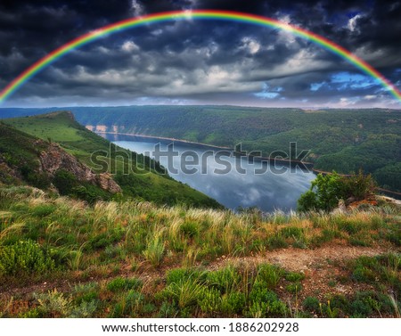 colorful rainbow over river canyon