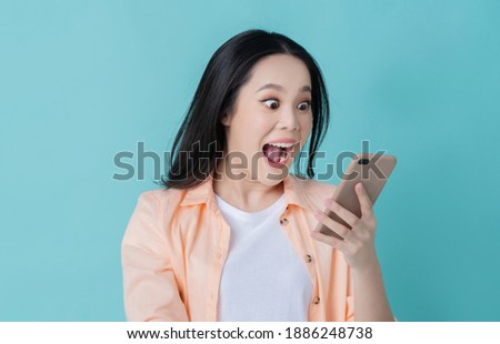 Beautiful Asian woman. She feels shocked with the phone 