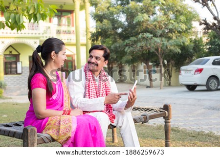 Rural Indian couple using digital tablet