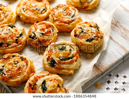French Puff Pastry Pinwheels stuffed with salmon, cheese and spinach on on baking paper, close up view  Royalty-Free Stock Photo #1886354848