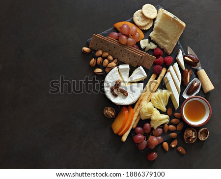 Appetizers platter with various of cheese, curred meat, sausage, olives, nuts and fruits. Festive family or party snack concept. Overhead view.