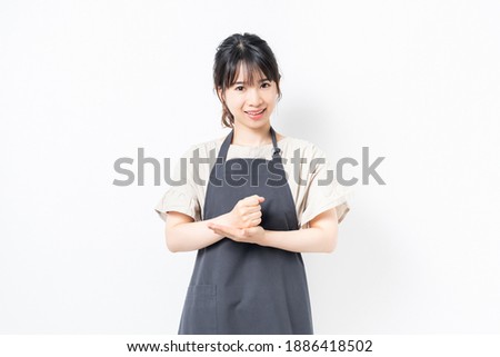 A young woman in an apron with a convincing gesture shot in the studio