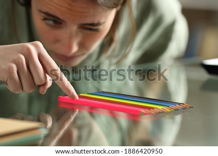 Obsessive compulsive woman aligning up pencils accurately on a glass table Royalty-Free Stock Photo #1886420950
