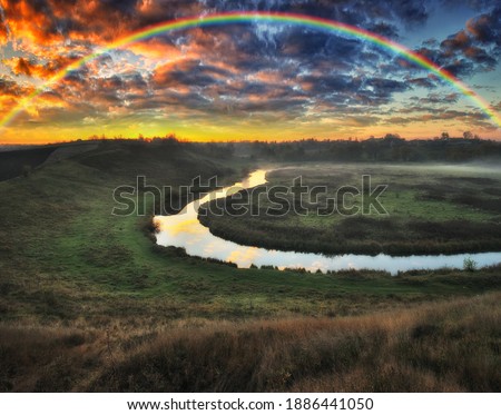 
Amazing rainbow over the small rural river. autumn morning

