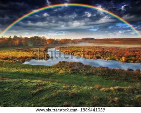 
Amazing rainbow over the small rural river. autumn morning
