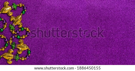 Carnival decoration banner. Mardi gras beads on glitter purple background Royalty-Free Stock Photo #1886450155