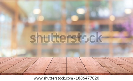 Empty wood table top and blur glass window interior restaurant and cafe banner mock up background - can used for display or montage your products.