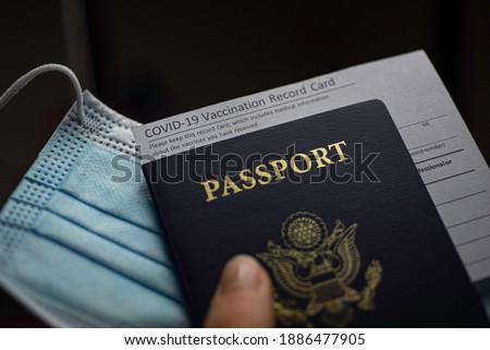 Blurred COVID-19 Vaccination Record card, Passport of USA and Medical Mask. Immune passport or certificate for travel concept.  Royalty-Free Stock Photo #1886477905