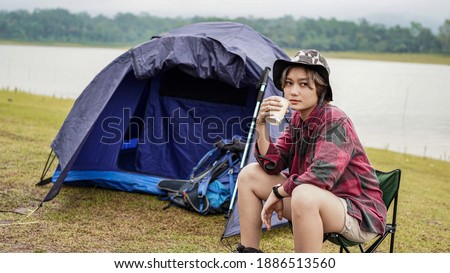young Asian female drink coffee in chair