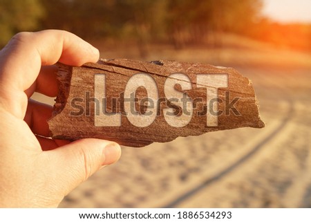 Business and miscellaneous concept. A man holds a sign in his hands - LOST