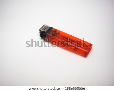 Red plastic gas lighter. Gas lighter isolated on white background. Closeup shot, top view.