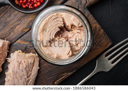 Canned tuna fillet meat in olive oil, on black background, flat lay Royalty-Free Stock Photo #1886586043