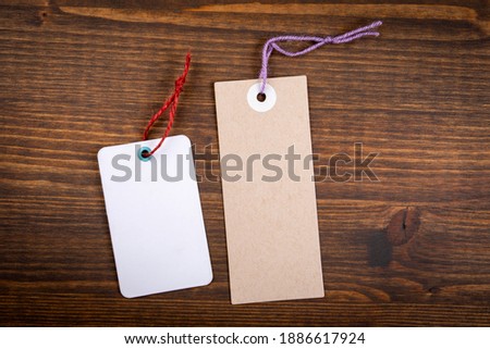 Cardboard and white paper price tags on a wooden texture background