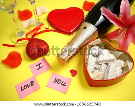 red box with heart shape with bow, bottle of champagne and two glasses, valentine's day party concept, closeup