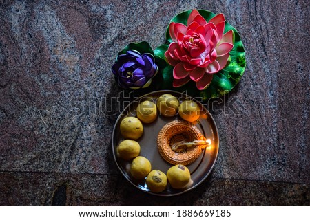 Delicious gram flours sweet dish ,made up during diwali festival in India. Decorated with flowers and oil lamp.