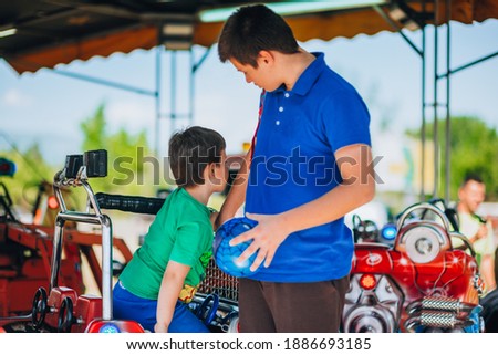 Little cheerful kid playing and having fun on the merry go round