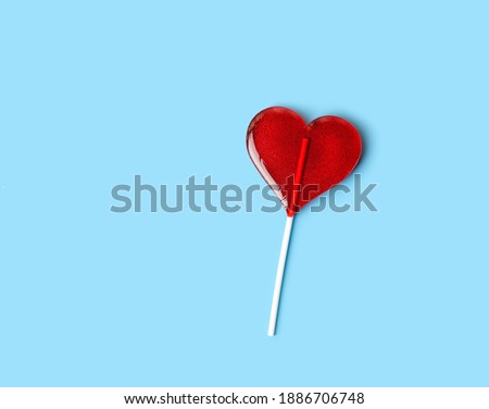 red Lollipop heart on abstract blue background. heart shape candy on stick, romantic sweet gift. symbol of love. Valentine's day, 14 february concept. flat lay. copy space. element for design. Royalty-Free Stock Photo #1886706748