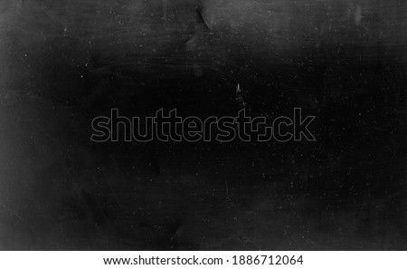 Dust scratched background. Aged chalkboard. Black faded weathered stained surface with gray smeared dirt grainy particles noise pattern.