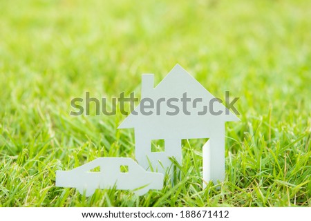 House white paper cut concept in green field background