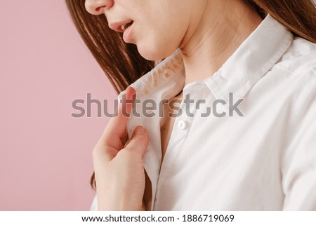 Hand showing dirty sweat and cosmetic stain on collar shirt from daily life activity. dirt stains for cleaning and washing concept Royalty-Free Stock Photo #1886719069