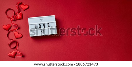 Love lightbox message with red hearts on red background. Top view flatlay.