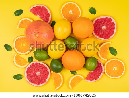 Flat lay oranges, lemon, lime with grapefruit on a yellow background in a high resolution. Ripe citrus fruit 