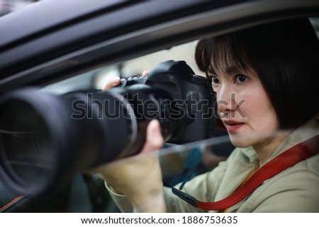 Woman taking pictures from inside the car
