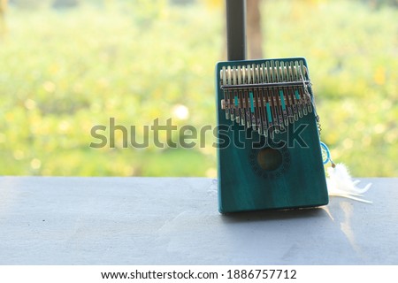 Kalimba or mbira is an African musical instrument.Traditional small Kalimba made from  wooden board with metal, play on  hands and plucking the tines with the thumbs. Instrument in room