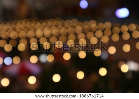 Blurry Colorful lights shining in a large room. The predominance of yellow light. Bokeh lights, defocused, great for backgrounds and wallpapers.
