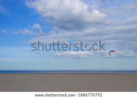 Kite surfing in the sea under the blue sky in the background