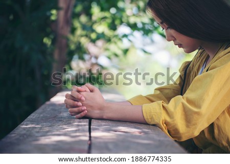 Prayer and bible concept. Asian female praying, hope for peace and free from coronavirus, Hand in hand together by woman, believes and faith in christian religion at church.