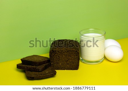Delicious sliced bread, a glass of fresh milk, boiled eggs on a yellow and green background. Healthy food concept. Foods you can eat on a bland diet. Copy space. Royalty-Free Stock Photo #1886779111
