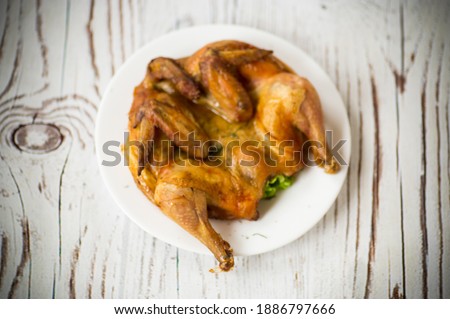 whole fried chicken in a plate on a wooden table