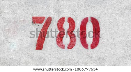 Red Number 780 on the white wall. Spray paint.