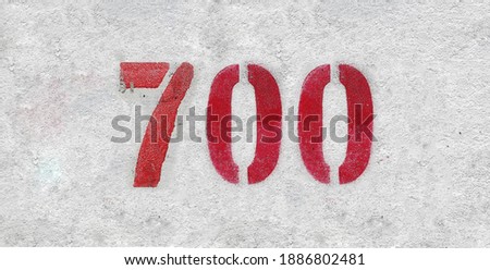 Red Number 700 on the white wall. Spray paint.