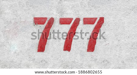 Red Number 777 on the white wall. Spray paint. Royalty-Free Stock Photo #1886802655