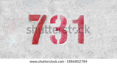 Red Number 731 on the white wall. Spray paint.
