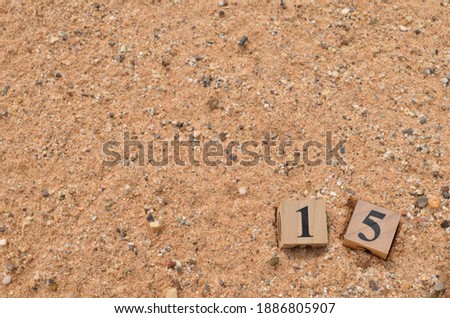 Number 15, rating, award, Empty cover design in natural concept with a number cube on sand background.