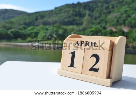 April 12, Date design with number cube on white table, cover design in natural concept.