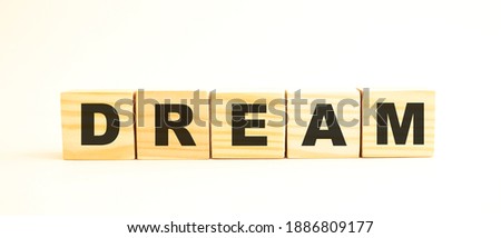 The word DREAM. Wooden cubes with letters isolated on white background.