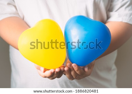 Heart-shaped balloons represent the sign of Down syndrome children. Balloons on hand